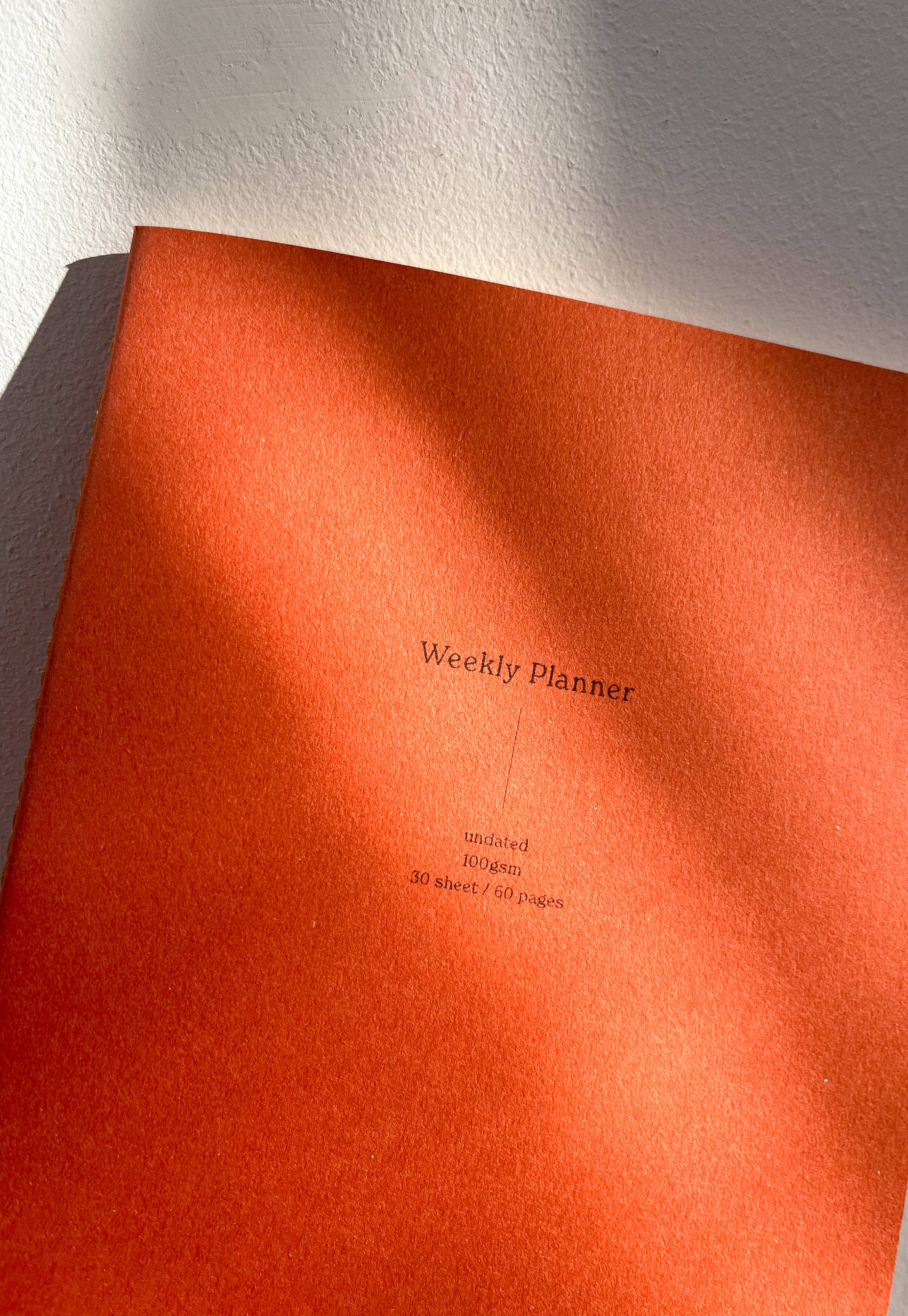 Orange weekly planner with text on a white background
