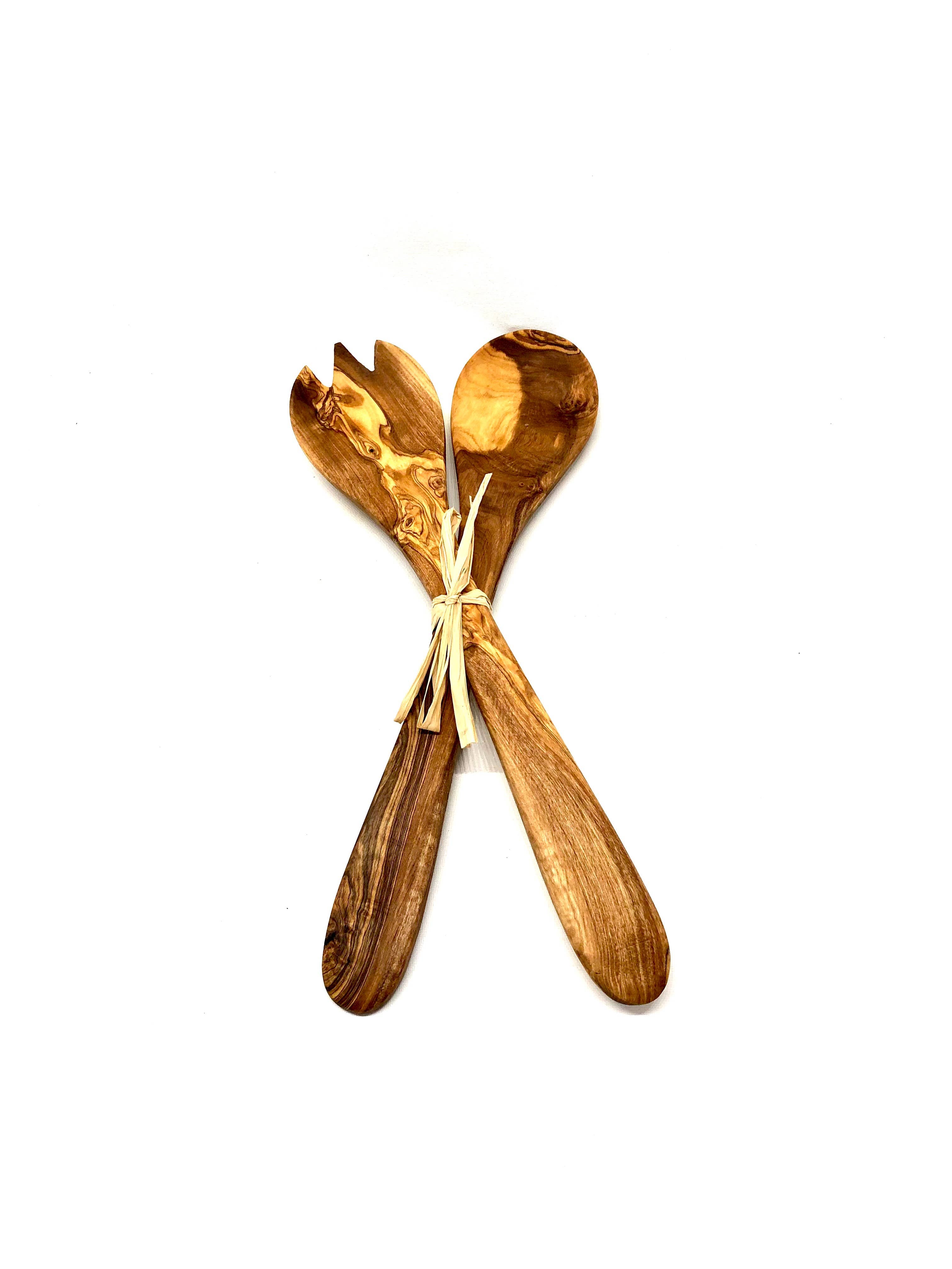 Two wooden salad servers tied together on a white background