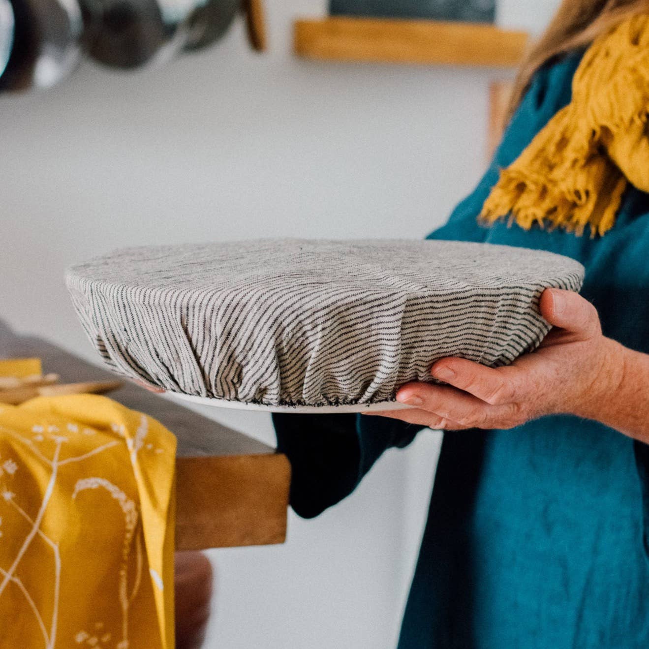 Person holding a striped bowl cover