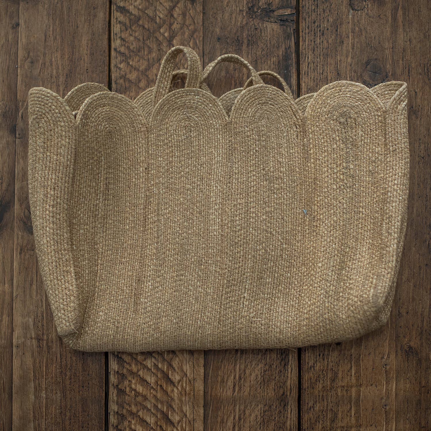 Woven basket with scalloped edge on a wooden surface