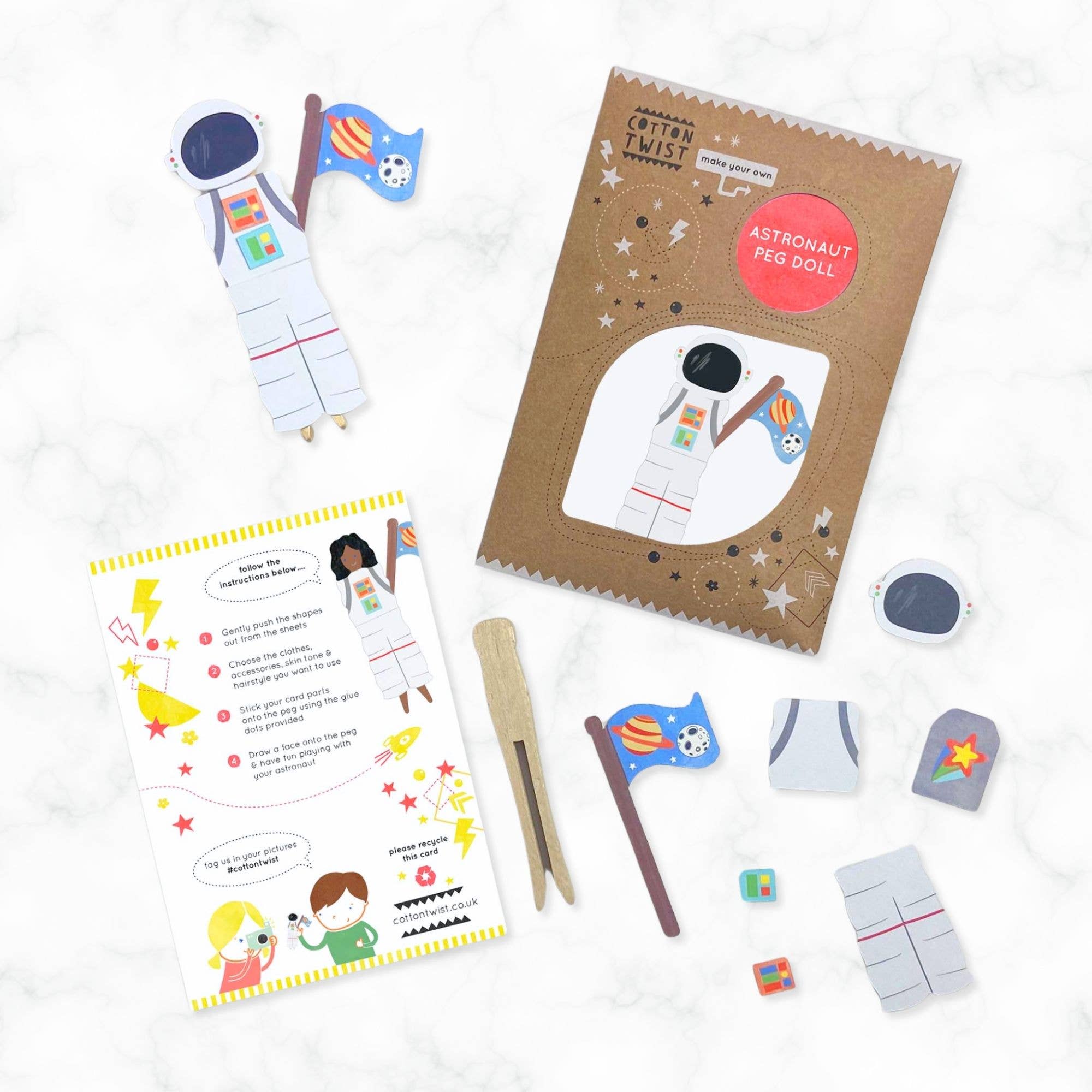 Astronaut peg doll kit with instructions, pegs, and flags on a white background