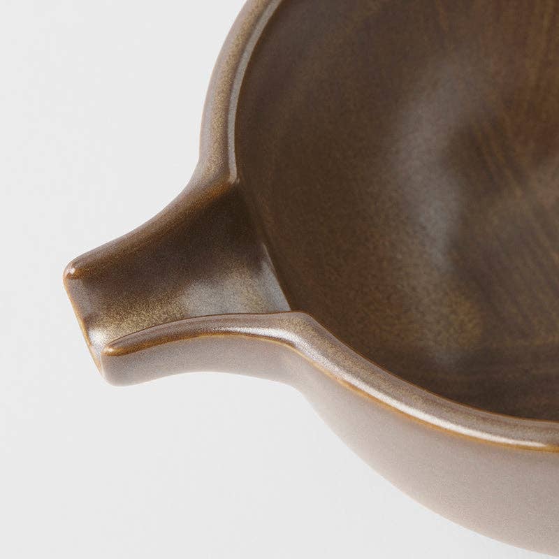 Close-up of a ceramic dish with a spout on a white background