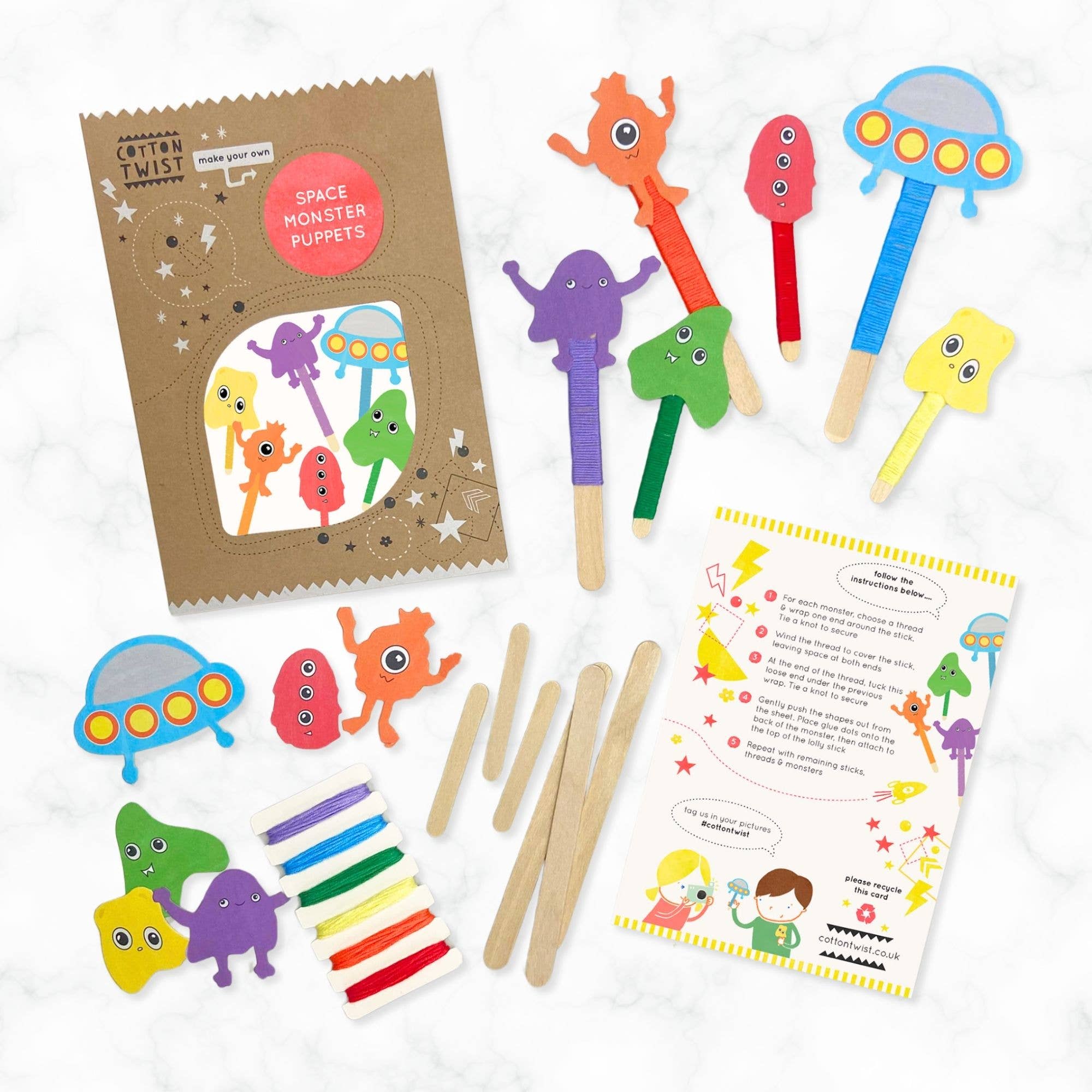 Space monster puppet kit with colorful puppets, craft sticks, and instructions on a white background