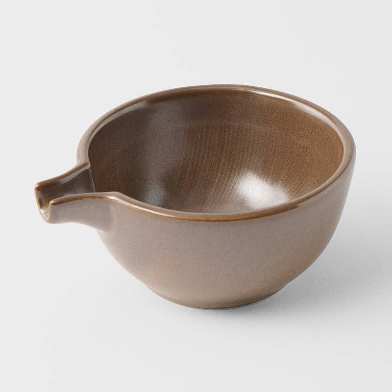 Brown ceramic bowl with a spout on a white background