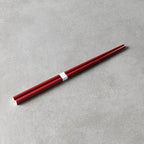 Red chopsticks on a gray surface