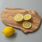 Wooden cutting board with sliced lemons on a gray background