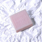 Pink soap bar with 'Savon Rose Provence' text on a white crumpled paper background