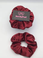 Two red scrunchies with a 'NerdyPud' label on a white background