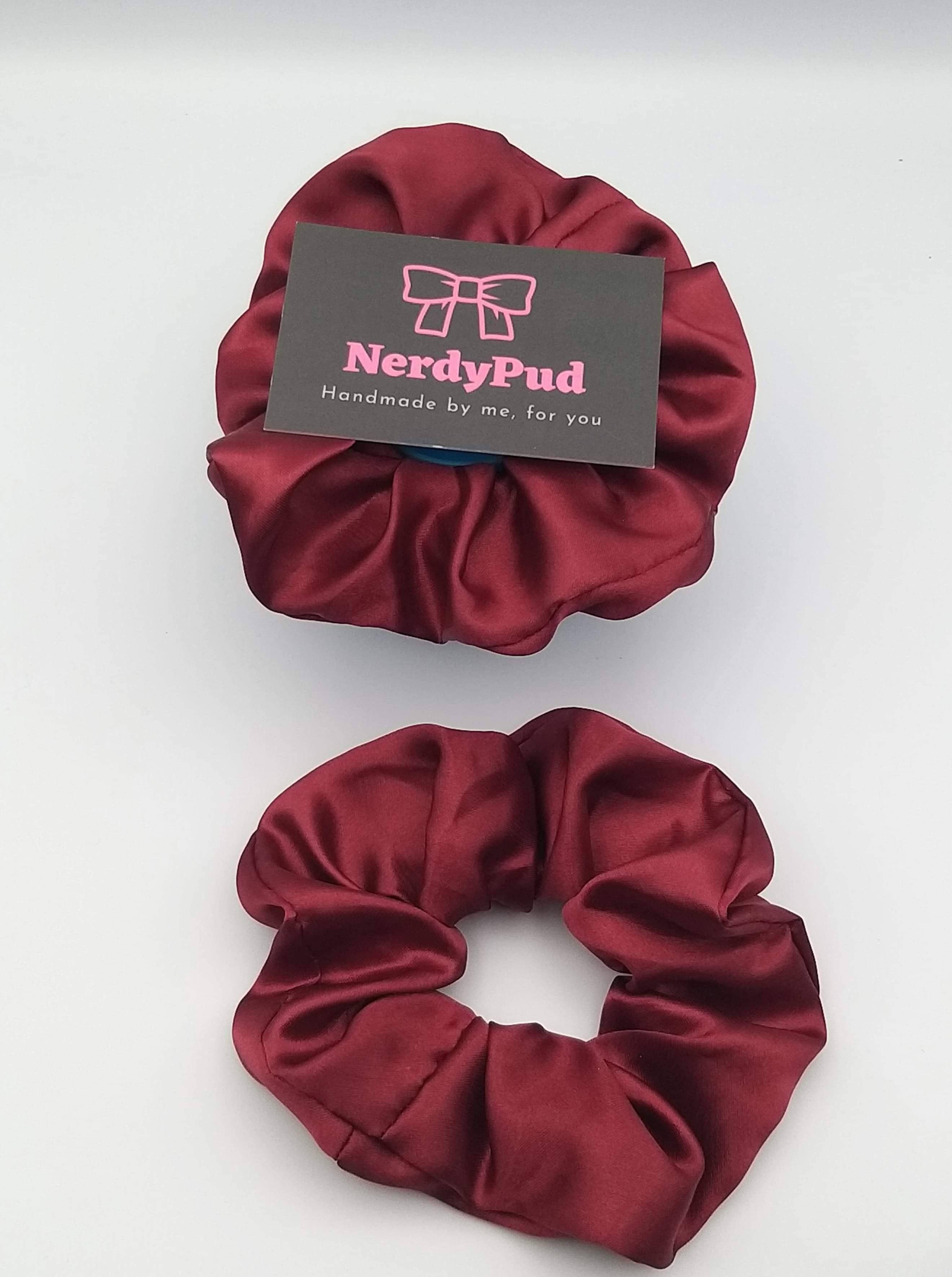 Two red scrunchies with a 'NerdyPud' label on a white background