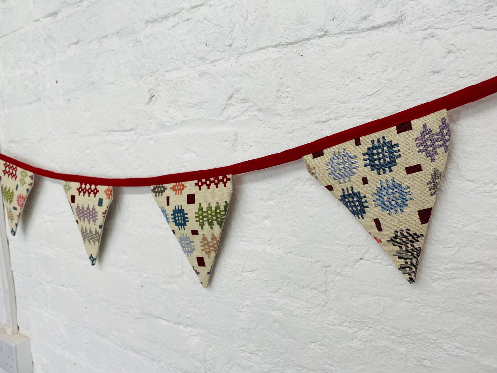 Fabric triangle banner with geometric patterns on a white wall