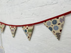 Fabric triangle banner with geometric patterns on a white wall
