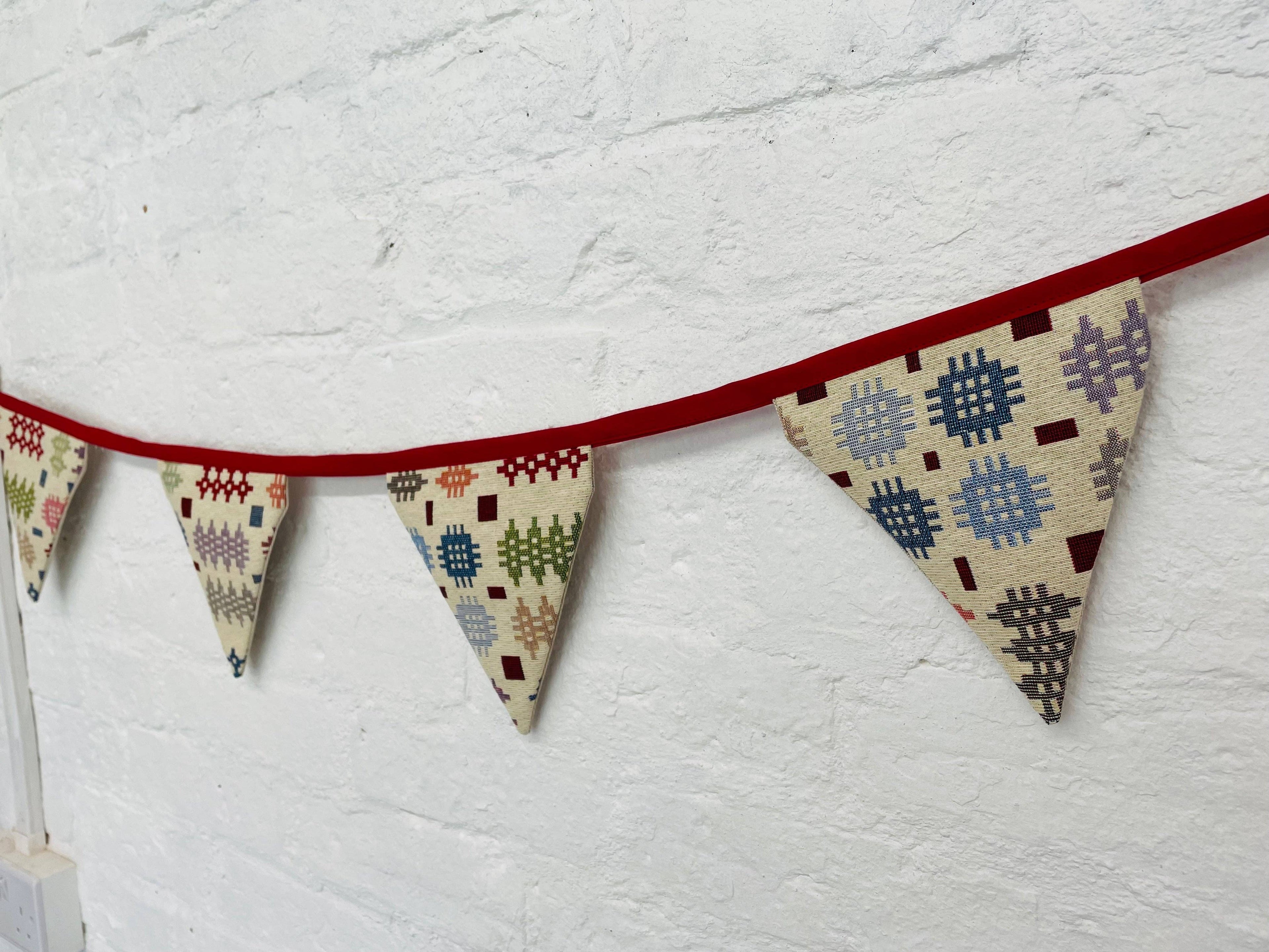 Fabric triangle banner with geometric patterns on a white wall