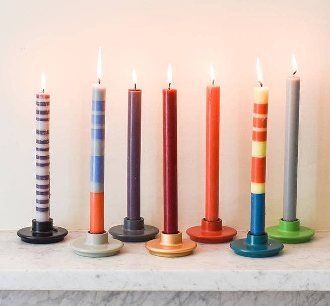 Set of colorful candles on a marble surface with a neutral background