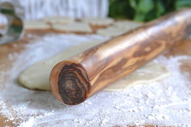 Wooden rolling pin on a wooden surface with flour