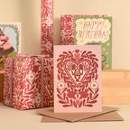 Decorative greeting card with floral pattern and envelope on a wooden surface