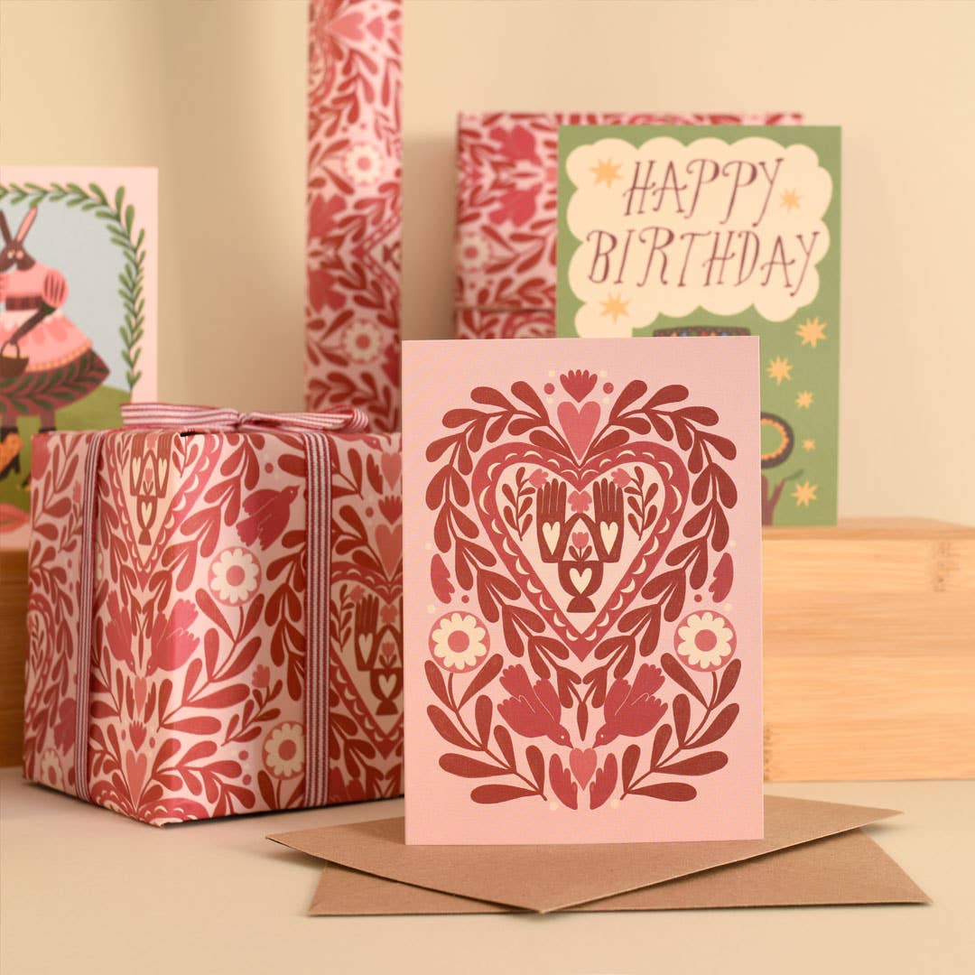 Decorative greeting card with floral pattern and envelope on a wooden surface