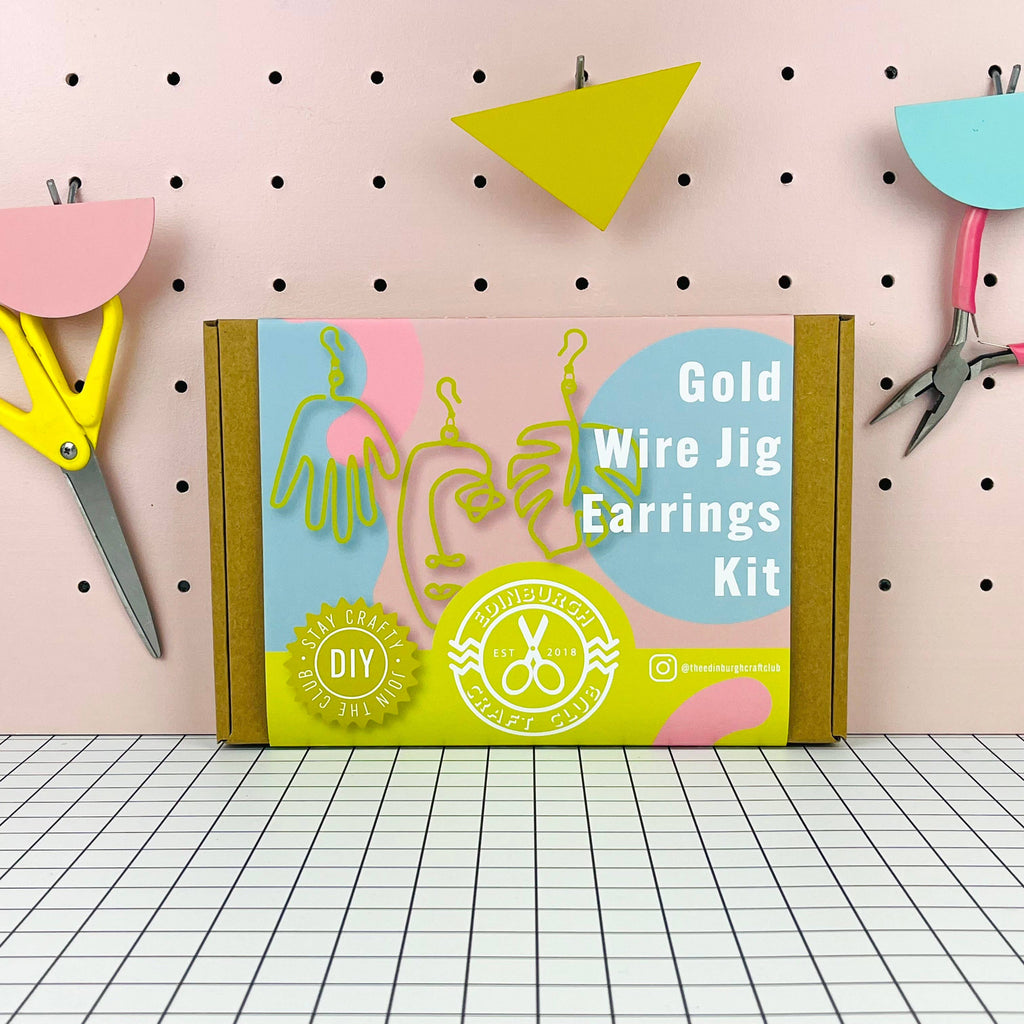 Gold Wire Jig Earrings Kit packaging on a pegboard background with crafting tools.