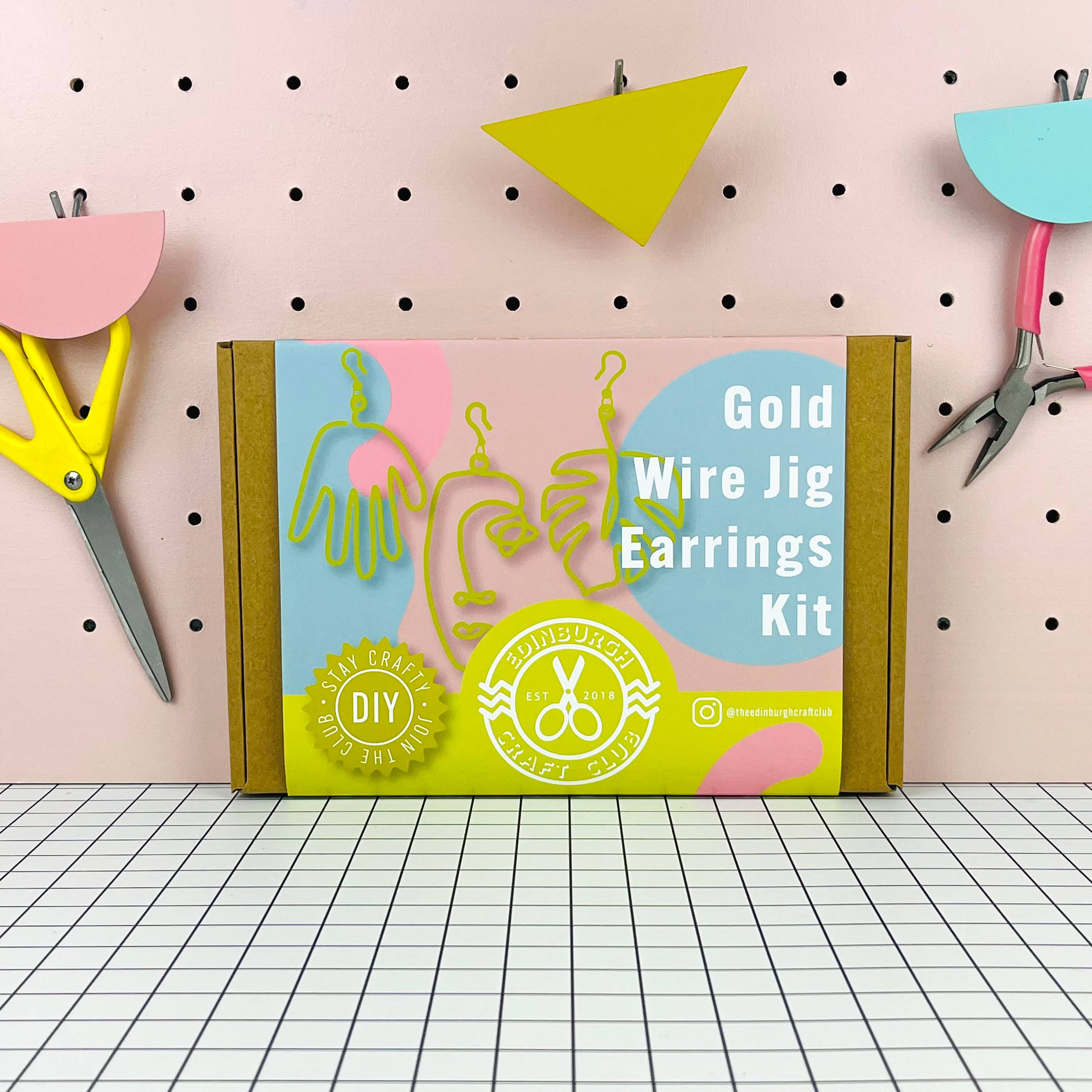 Gold Wire Jig Earrings Kit packaging on a pegboard background with crafting tools.