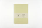 Light green notebook with a brand label on a white background