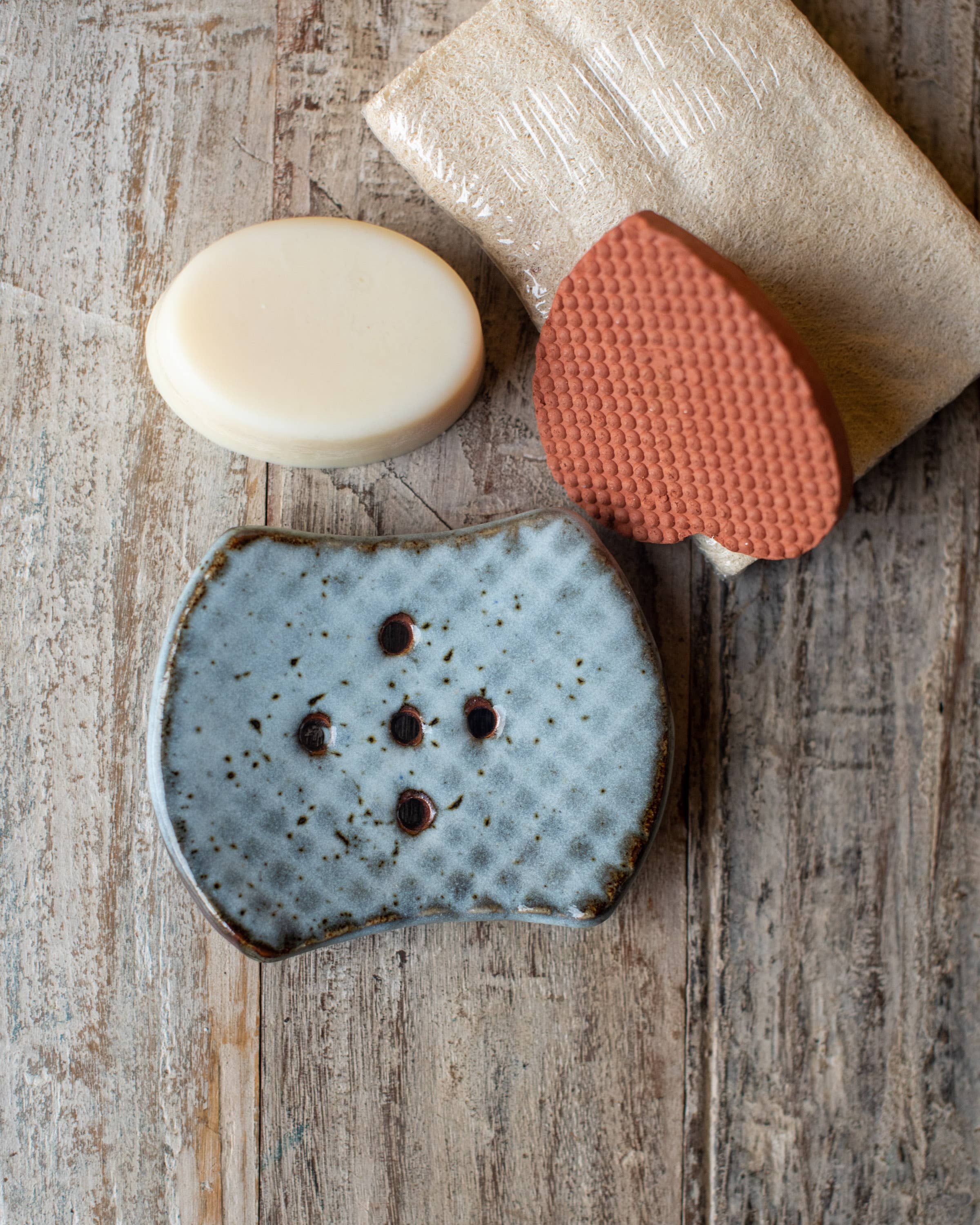 Soap bars on a wooden surface with blue speckled soap dish.