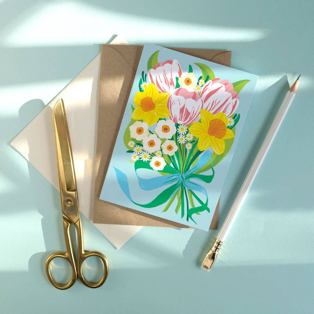 Floral card with gold scissors and pencil on a light blue background