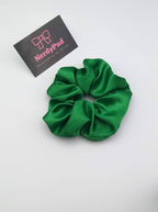 Green scrunchie with a branded card on a white background