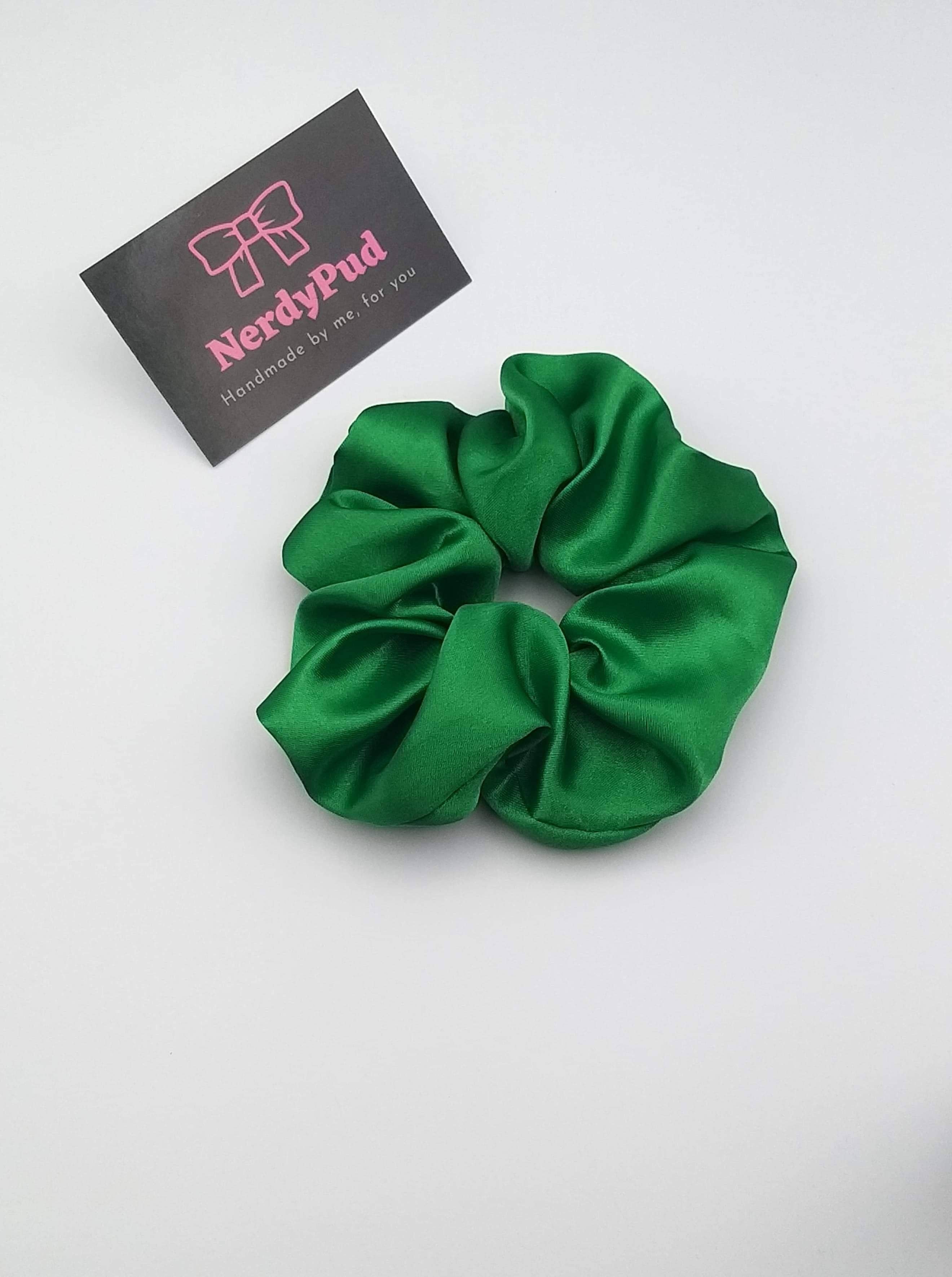 Green scrunchie with a branded card on a white background