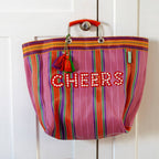 Colorful striped bag with 'CHEERS' text on a white background