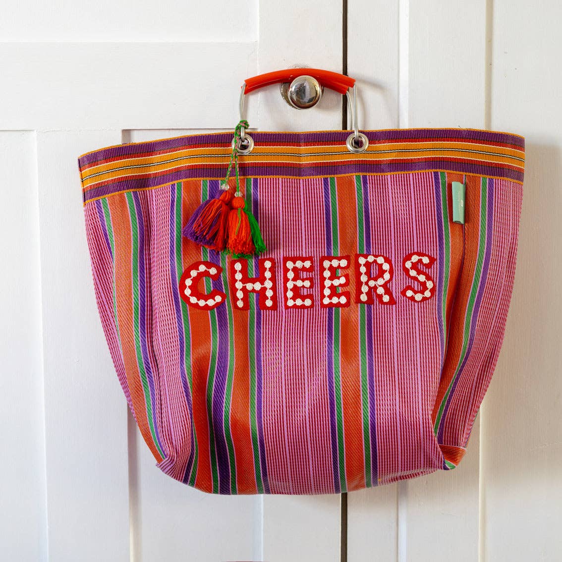 Colorful striped bag with 'CHEERS' text on a white background