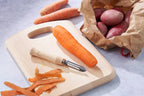 vgetable peeler surrounded by carrots and potatoes
