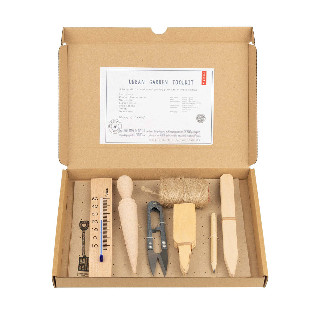 Box containing an urban garden toolkit with various gardening tools on a white background