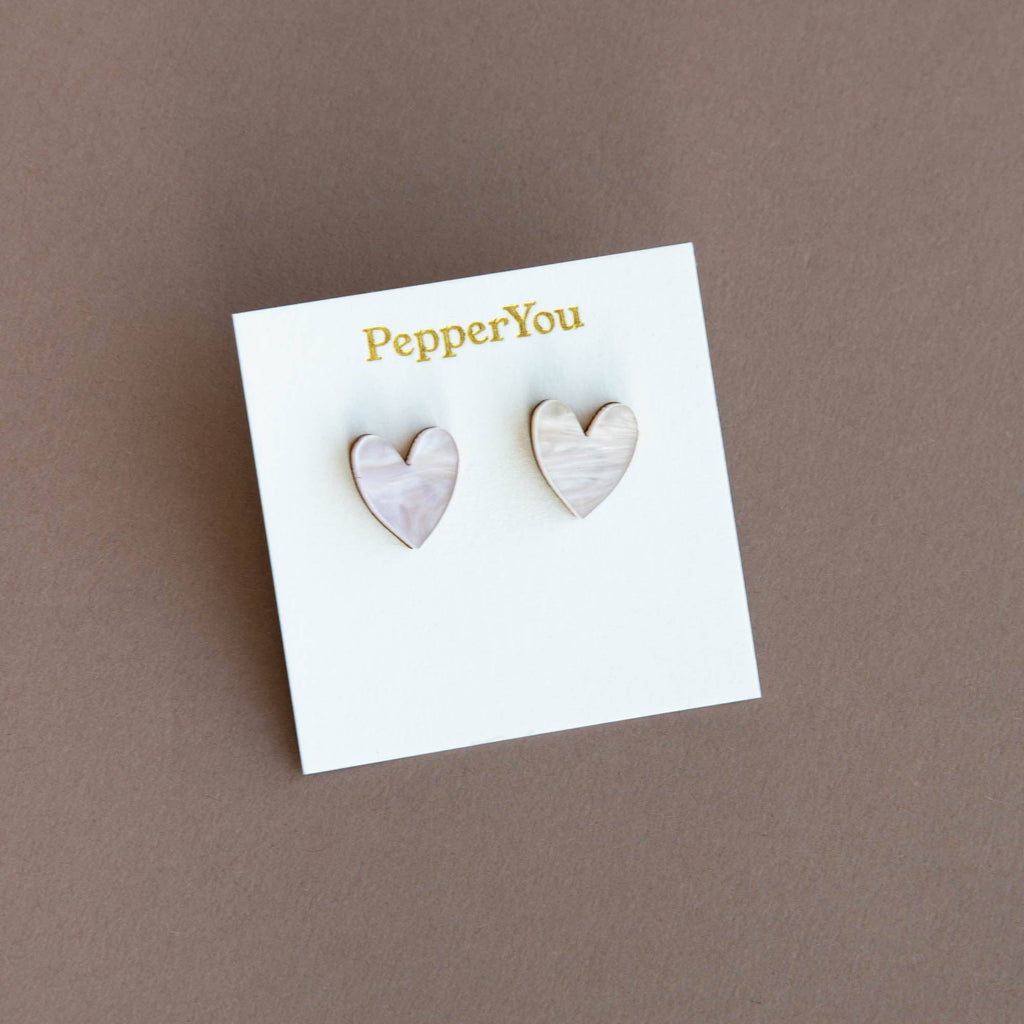 Heart-shaped earrings on a 'PepperYou' branded card against a brown background
