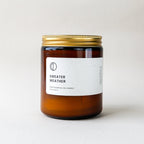 Candle labeled 'Sweater Weather' with a gold lid on a light background