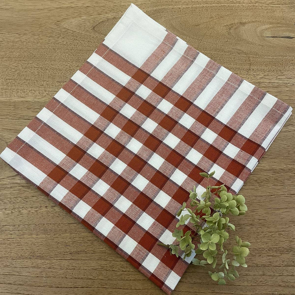 Checkered fabric napkin with red and white pattern on a wooden surface