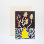 Greeting card with a yellow vase and floral design on a black background, accompanied by a beige envelope.