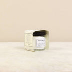 Cut flower food in a glass jar with a black lid on a beige background