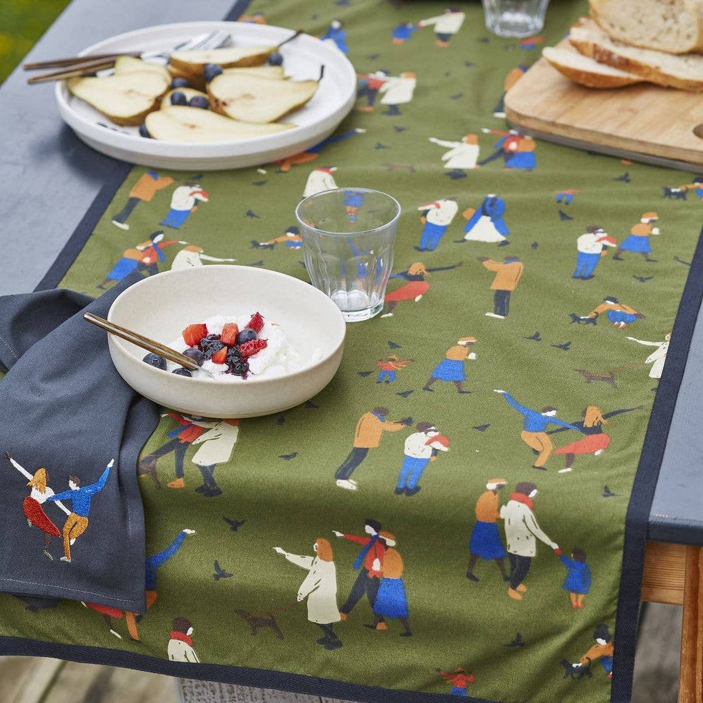 Table setting with a green tablecloth featuring small figures