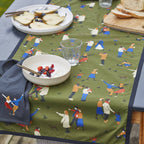 Table setting with a green tablecloth featuring small figures
