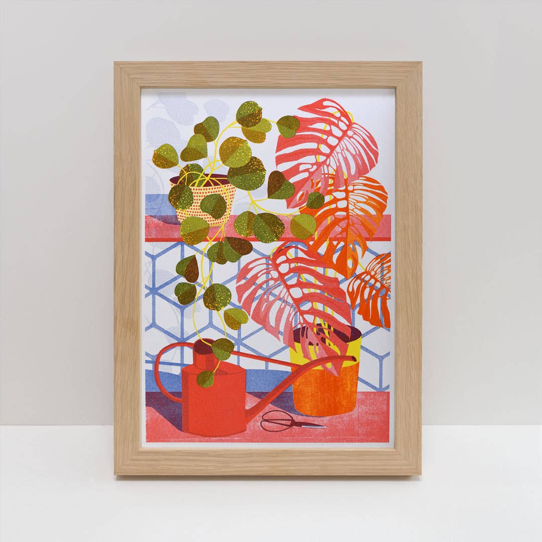 Framed artwork with plants and a watering can on a white background