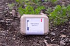 Herb garden seed kit on soil with plants growing around