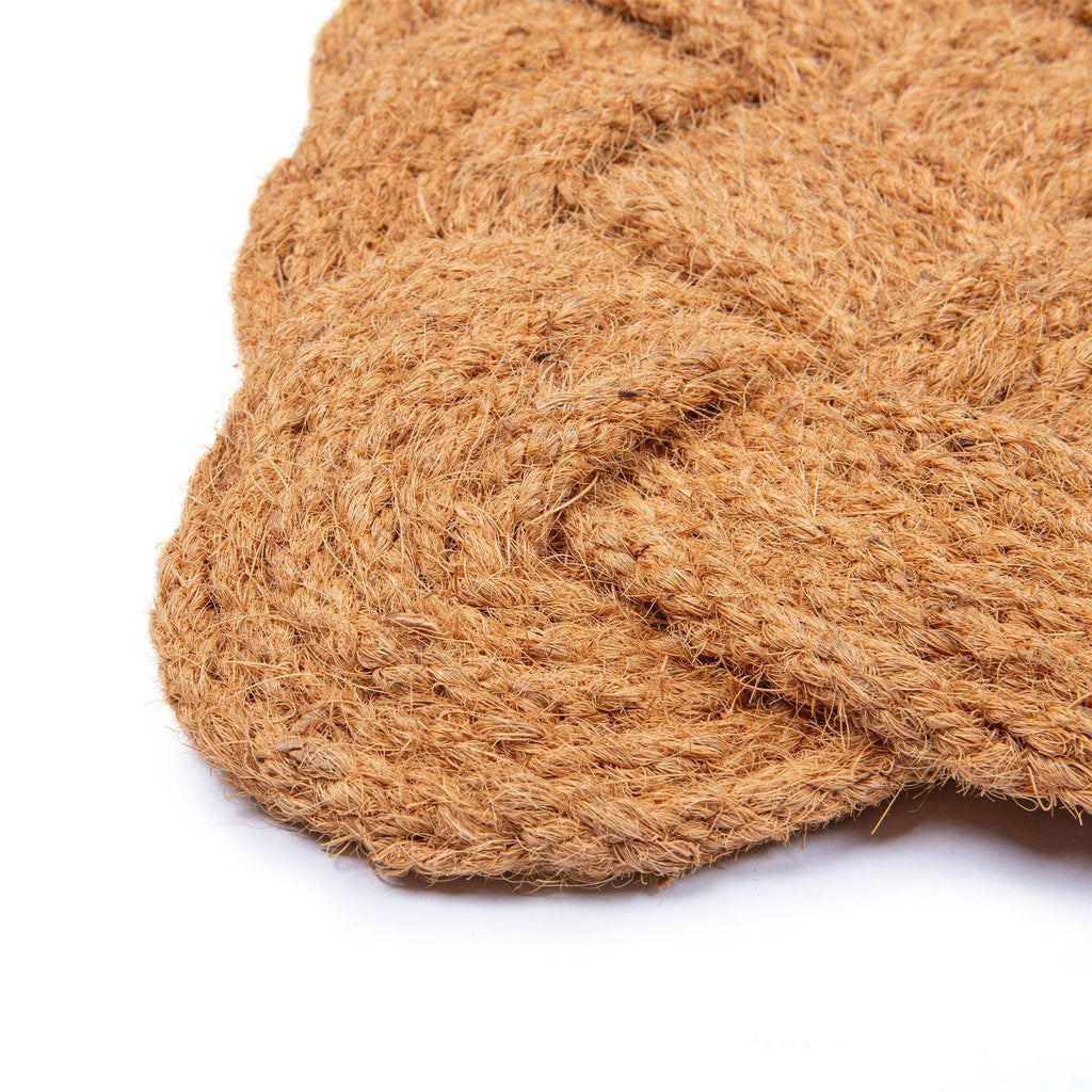 Close-up of a textured brown doormat on a white background