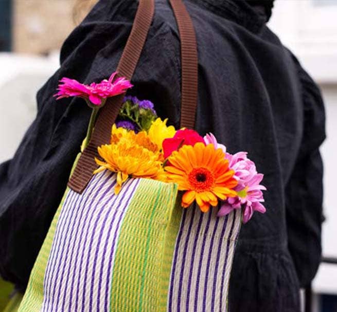 Striped bag with colorful flowers attached to it