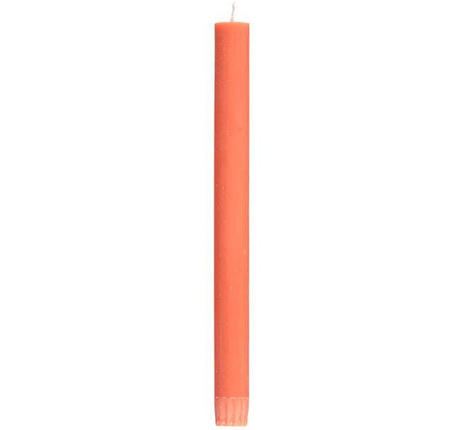 Single orange candle on a white background