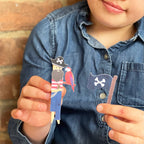 Child holding a pirate-themed paper toy with a parrot against a wooden background