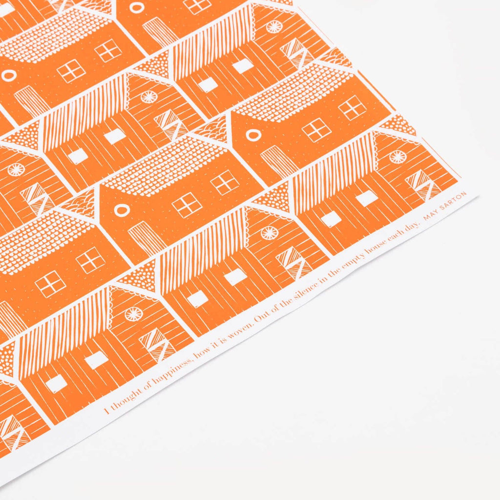 Patterned paper with orange and white house design on a white background