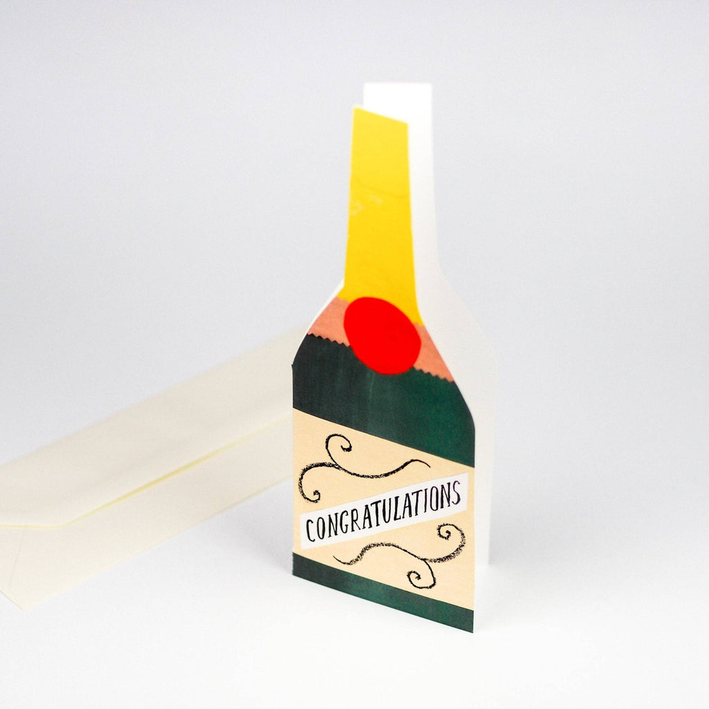 Tall rectangular champagne greetings card standing up on a grey background - All Good Things