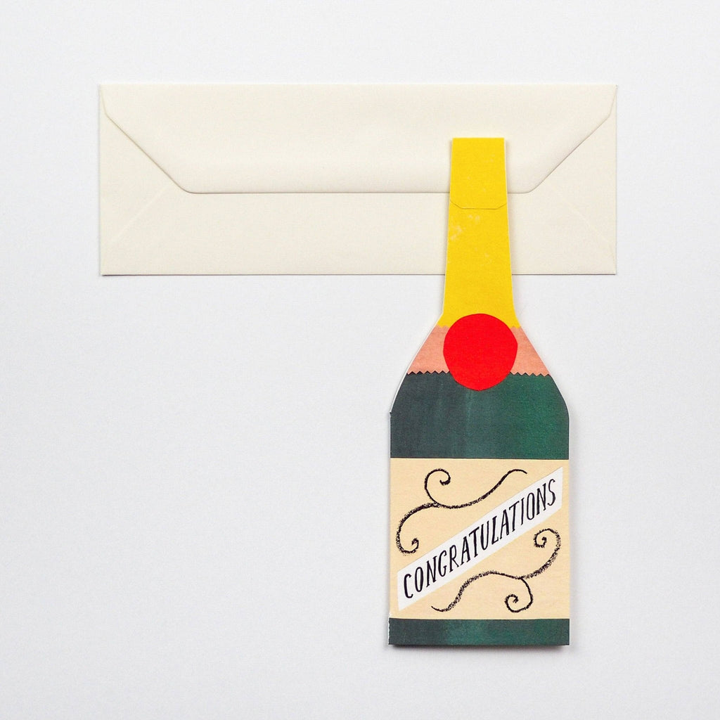 Tall rectangular greetings card featuring champagne bottle design and cream envelope on a grey background - All Good Things