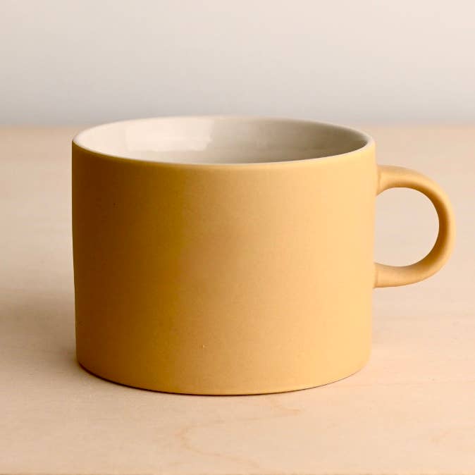 Yellow mug on a beige background