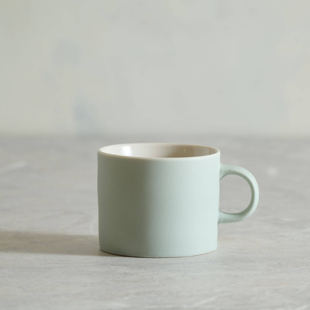 Light blue ceramic mug on a light gray background