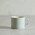 Light blue ceramic mug on a light gray background